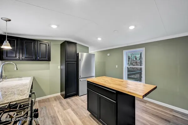 an empty room with wooden floor ceiling fan and windows