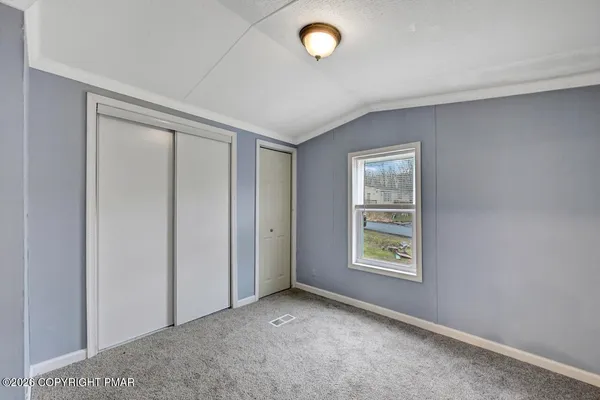 an empty room with windows and closet