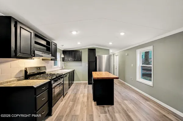 a view of empty room with wooden floor and fireplace