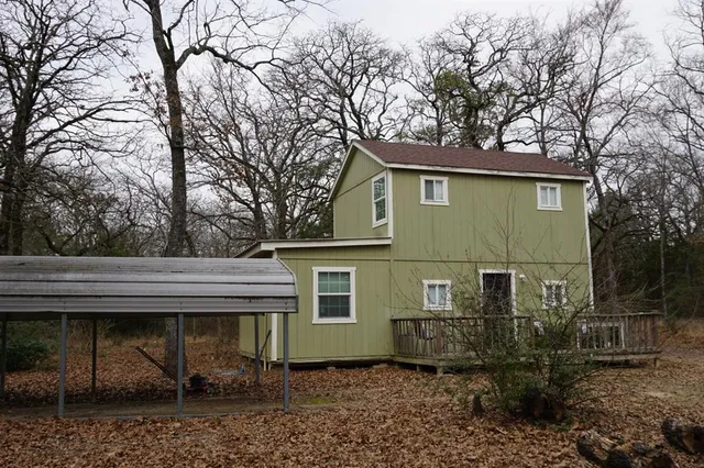 a view of a house with a yard and large tree