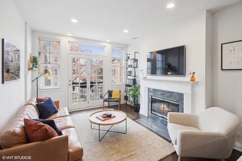 a living room with furniture a flat screen tv and a fireplace