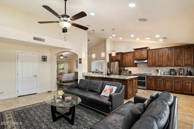 a living room with furniture kitchen view and a chandelier