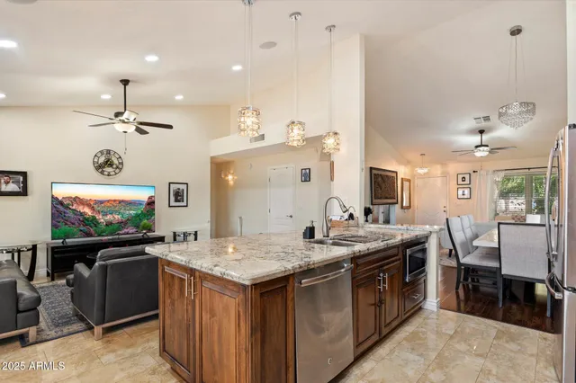 a open kitchen with stainless steel appliances granite countertop a stove and a refrigerator