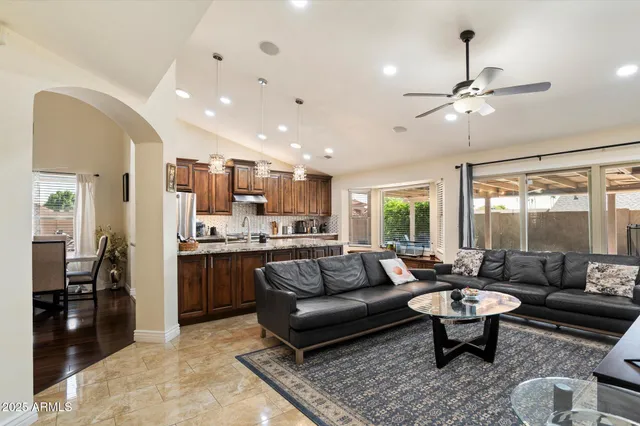 a living room with stainless steel appliances kitchen island granite countertop furniture and a couch
