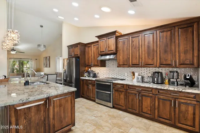 a kitchen with stainless steel appliances granite countertop a sink stove and refrigerator