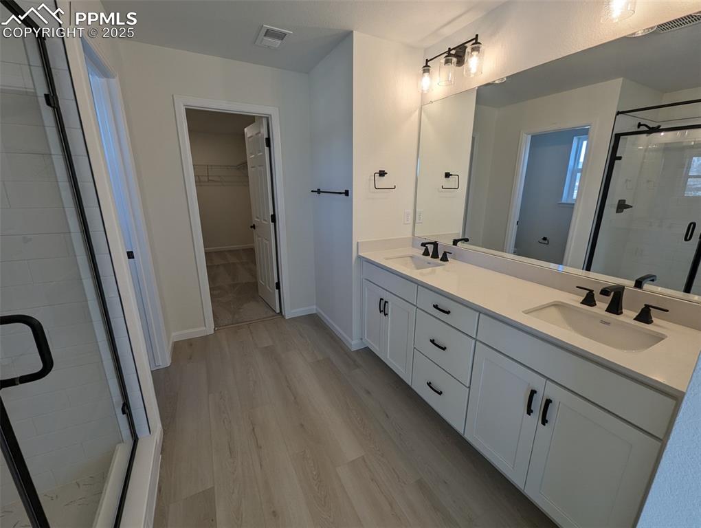 16966 Starfall Drive Monument, CO 80132 - Photo 12 of 18 a spacious bathroom with a double vanity sink a mirror and a shower