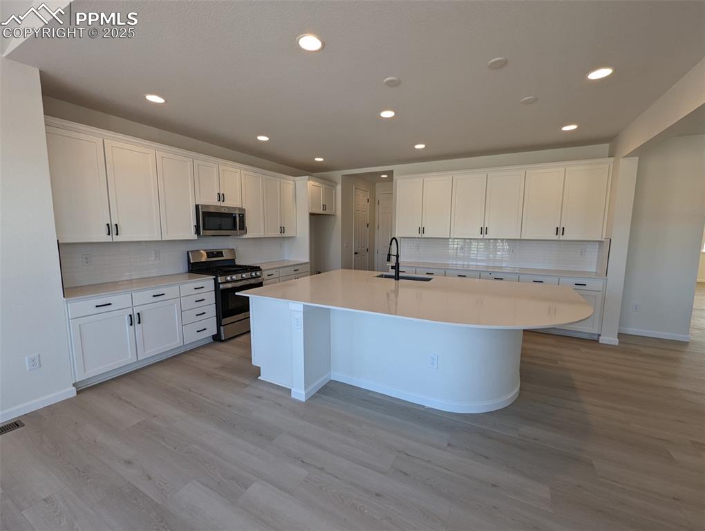 16966 Starfall Drive Monument, CO 80132 - Photo 2 of 18 a large kitchen with kitchen island a sink a center island and stainless steel appliances