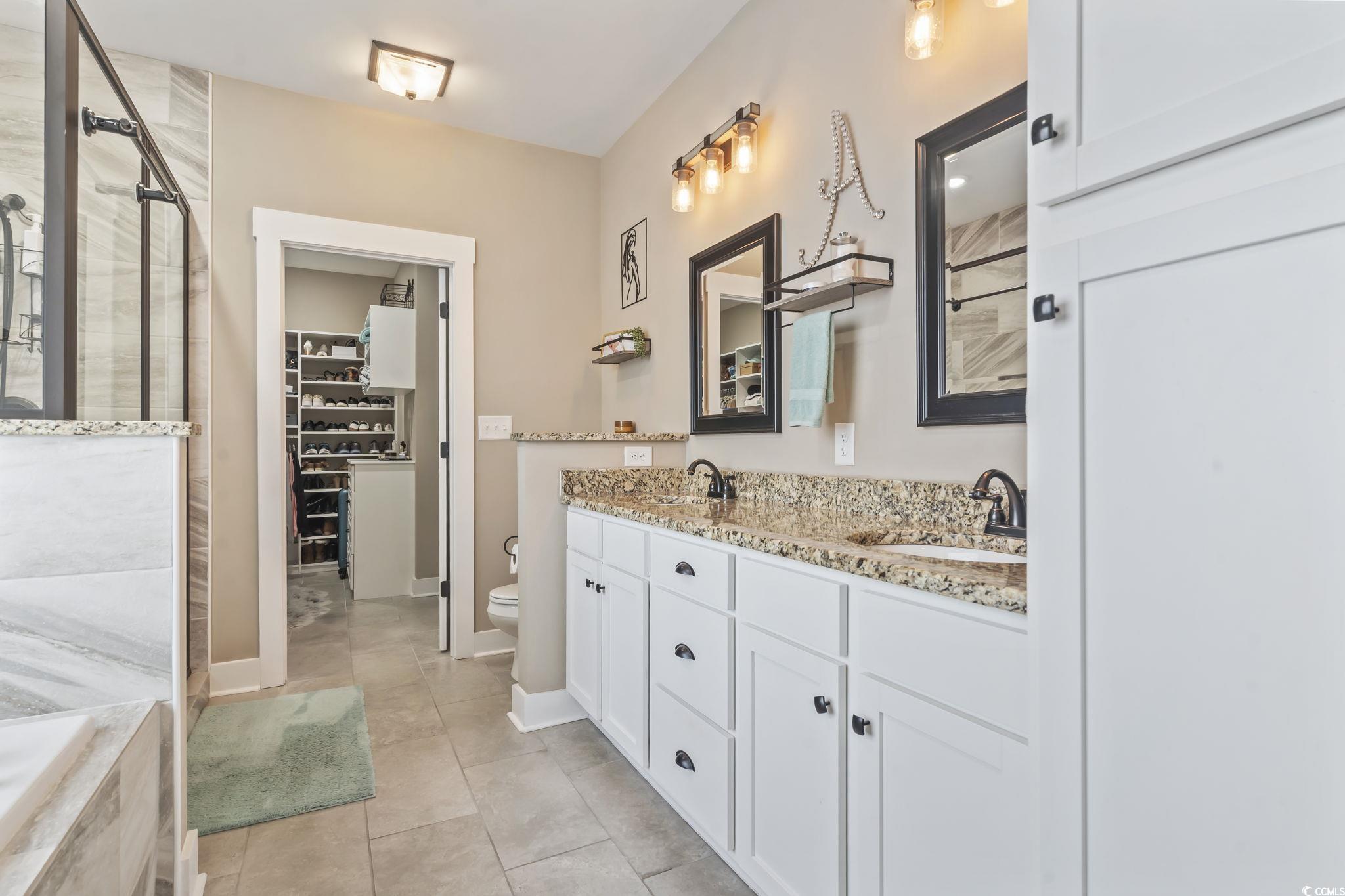 175 Rivers Edge Drive Conway, SC 29526 - Photo 17 of 37 Bathroom with double vanity, a shower stall, a spacious closet, light tile patterned floors, and a bath