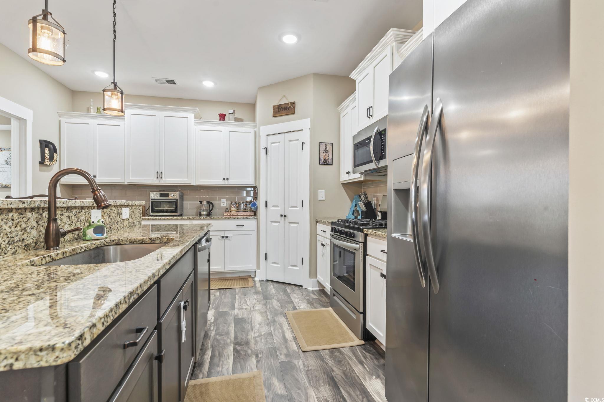 175 Rivers Edge Drive Conway, SC 29526 - Photo 10 of 37 Kitchen with stainless steel appliances, white cabinetry, light stone counters, decorative backsplash, and recessed lighting
