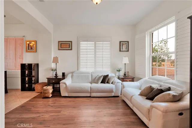a living room with furniture a flat screen tv and a floor to ceiling window