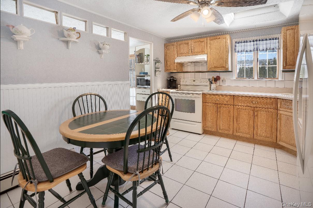69 Riviera Drive Selden, NY 11784 - Photo 11 of 20 a kitchen with stainless steel appliances a dining table chair and window