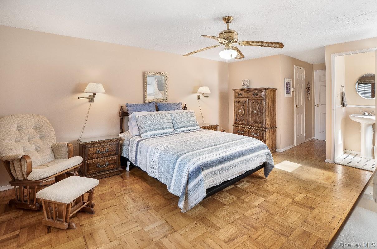 69 Riviera Drive Selden, NY 11784 - Photo 14 of 20 a spacious bedroom with a bed and a chandelier