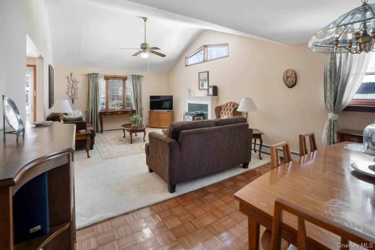 69 Riviera Drive Selden, NY 11784 - Photo 7 of 20 a living room with furniture a fireplace a flat screen tv and a large window