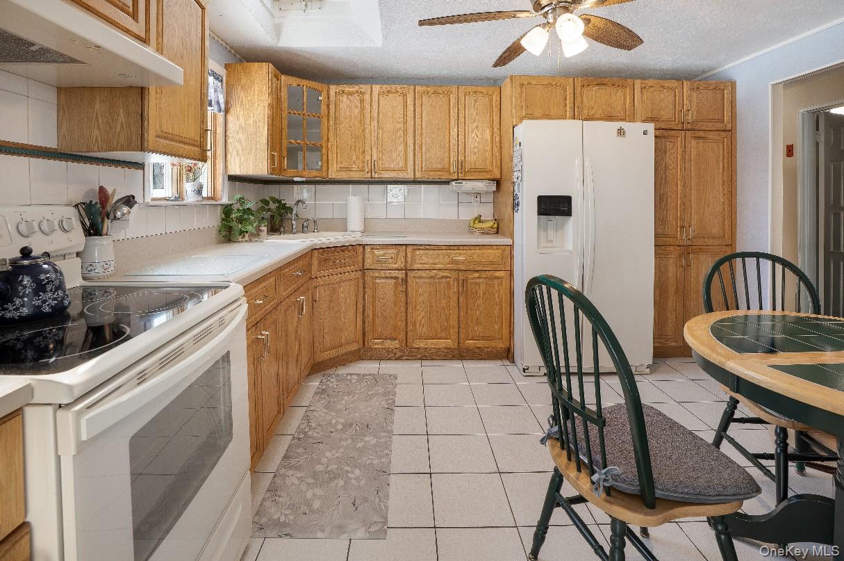 69 Riviera Drive Selden, NY 11784 - Photo 10 of 20 a kitchen with a table chairs refrigerator and cabinets