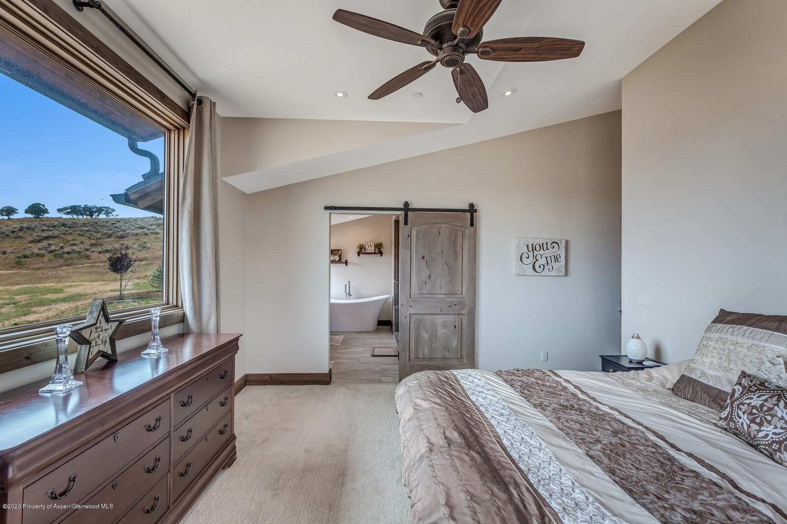 1009 Cattle Creek Ridge Road Carbondale, CO 81623 - Photo 15 of 40 a bedroom with a bed dresser and a large window