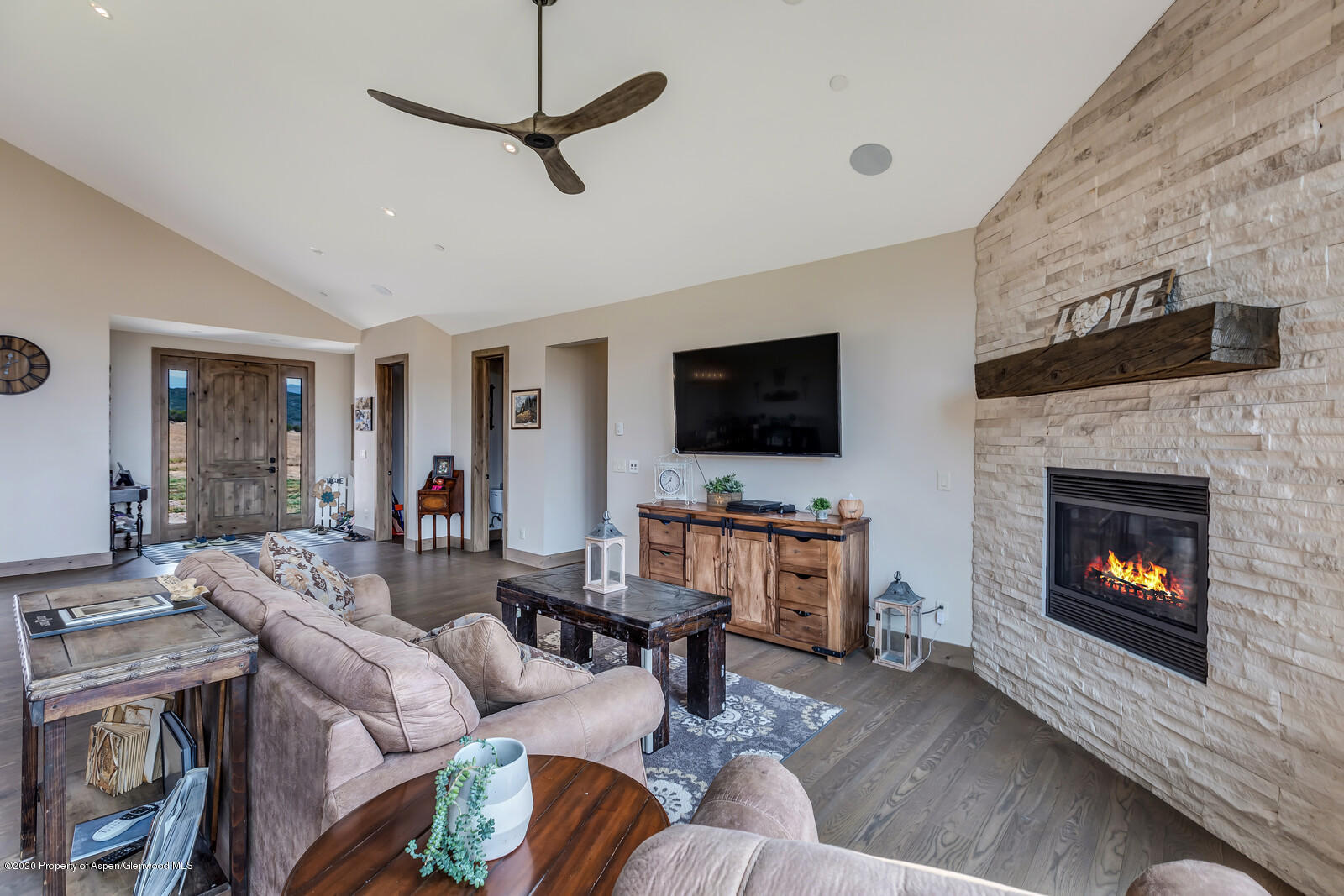 1009 Cattle Creek Ridge Road Carbondale, CO 81623 - Photo 4 of 40 a living room with furniture a flat screen tv and a fireplace
