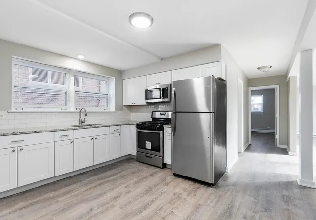 a kitchen with stainless steel appliances a refrigerator sink and cabinets
