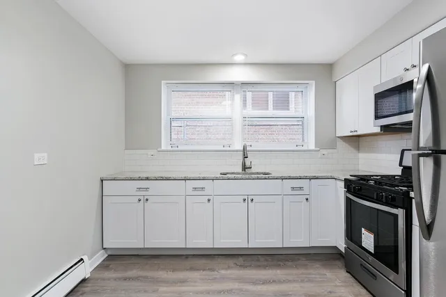 a kitchen with stainless steel appliances granite countertop a stove a sink and a microwave