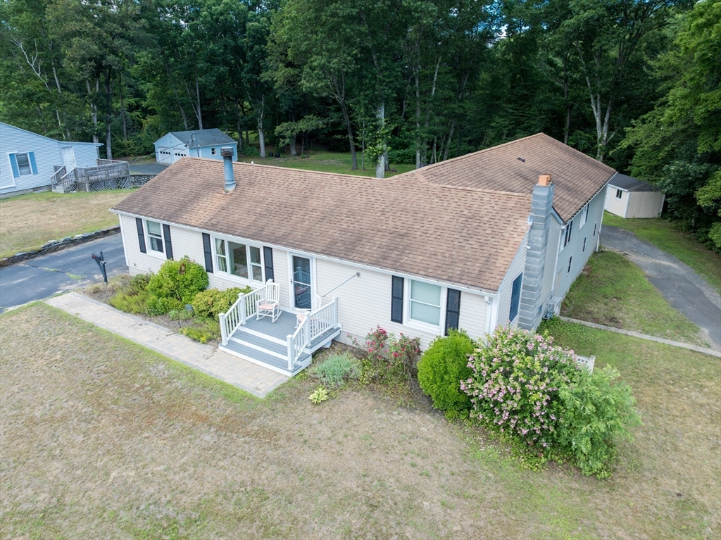 a aerial view of a house with a yard and large trees
