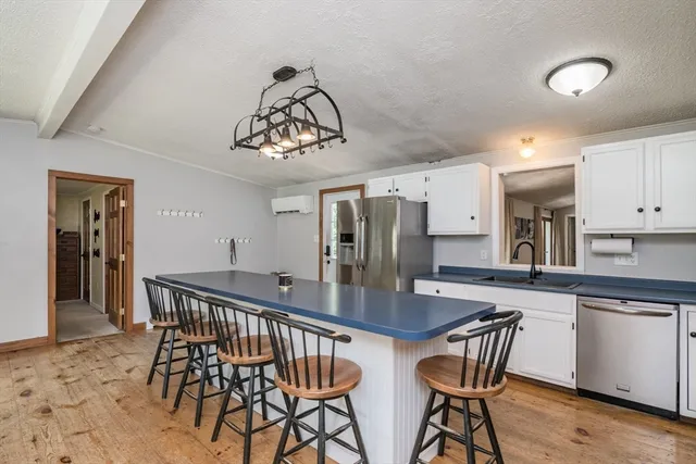 a kitchen with stainless steel appliances granite countertop a dining table and chairs in it