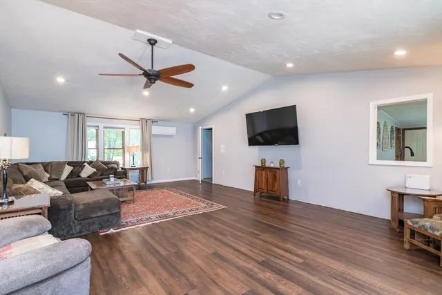 a living room with furniture ceiling fan and a flat screen tv