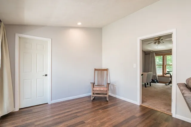 a view of a room with wooden floor lounge chair and windows