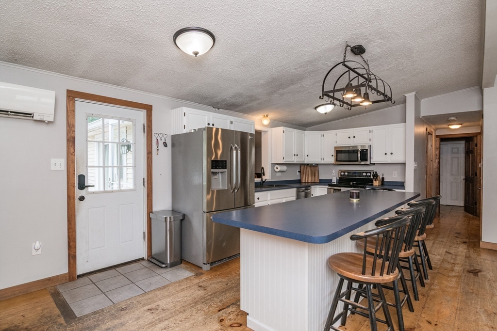 183 Millers Falls Road Montague, MA 01376 - Photo 8 of 33 a kitchen with stainless steel appliances a table chairs and chandelier