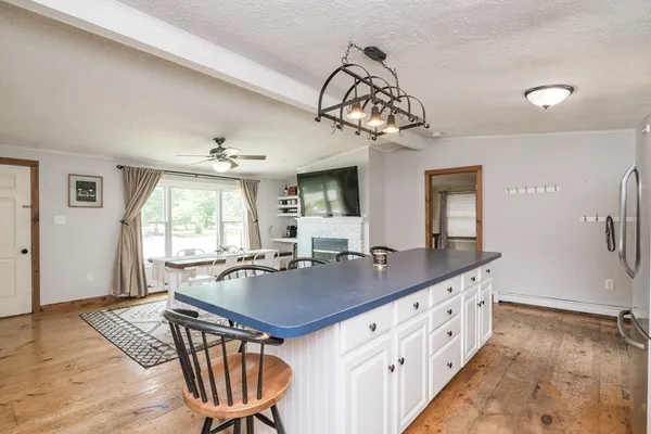 a kitchen with stainless steel appliances granite countertop a sink dishwasher a stove a dining table and chairs with wooden floor