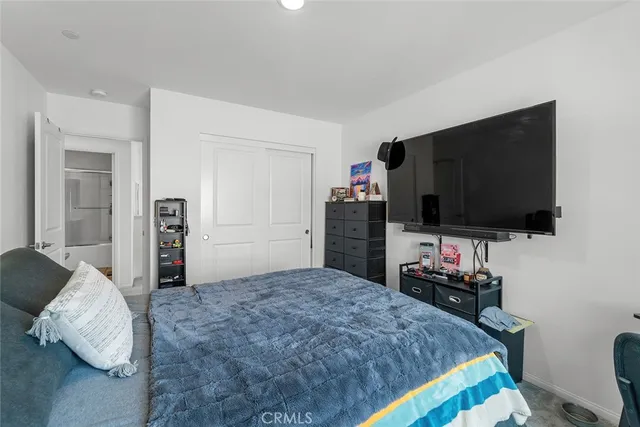 a bedroom with a bed and a flat screen tv