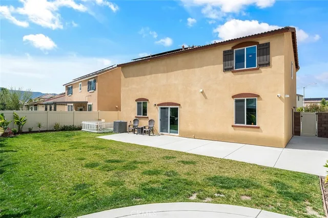 a view of a house with backyard and sitting area
