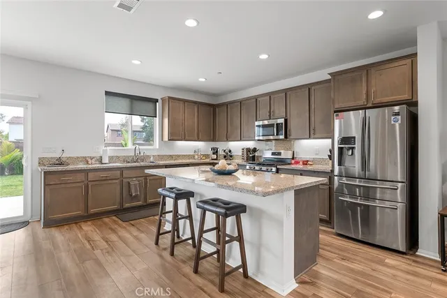 a kitchen with a refrigerator a sink a stove a microwave and cabinets