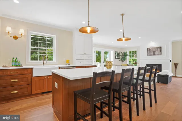 a kitchen with stainless steel appliances granite countertop a table chairs stove and refrigerator
