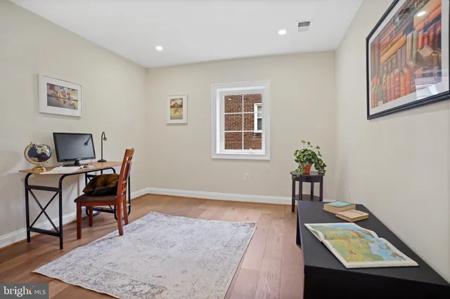 a view of a hallway with wooden floor and stairs