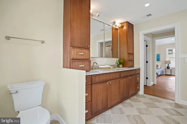 a bathroom with a double vanity sink mirror and toilet