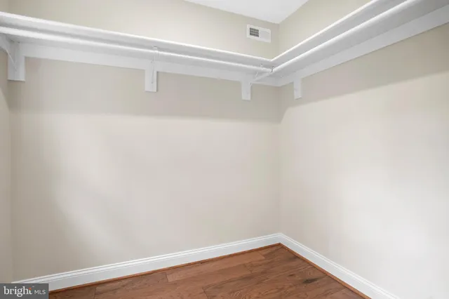 a view of a kitchen with refrigerator and wooden floor