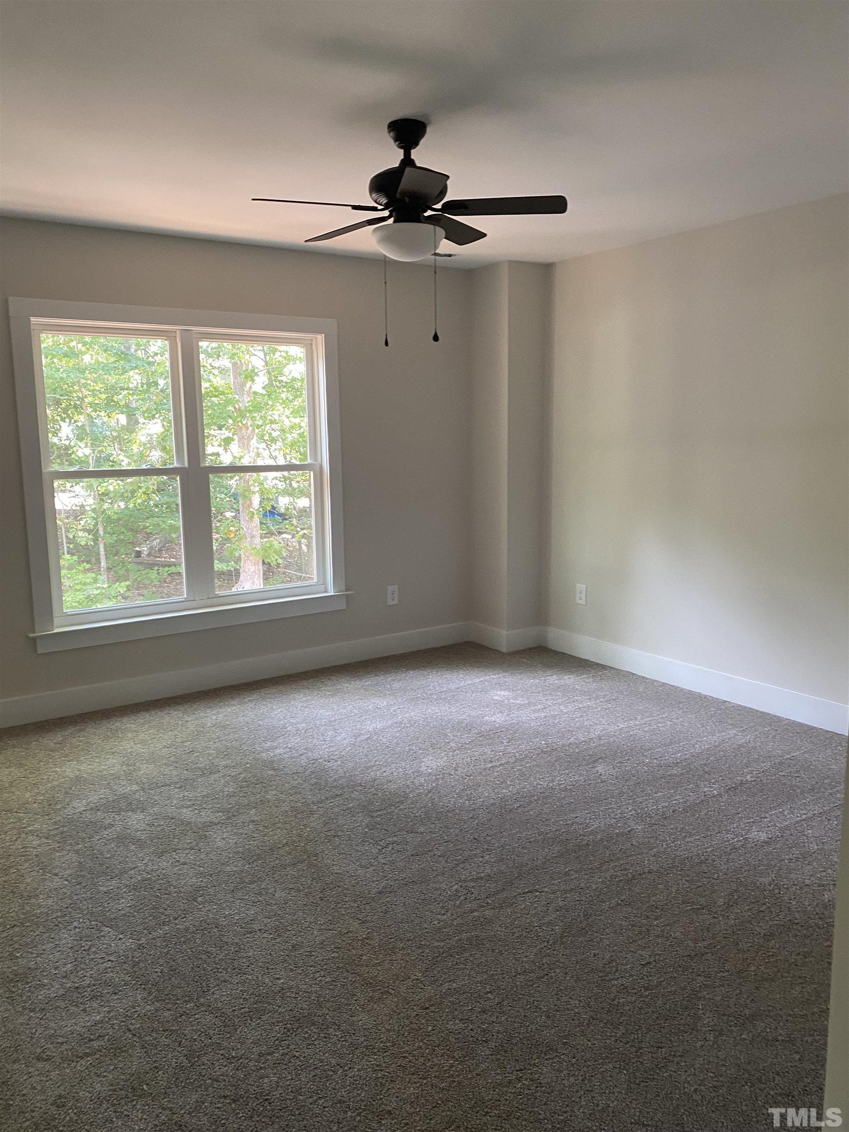 1108 Hammerman Drive Willow Spring, NC 27592 - Photo 13 of 22 an empty room with a ceiling fan and windows