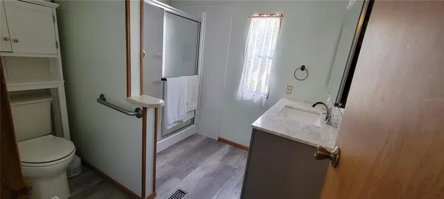 a bathroom with a granite countertop sink toilet and shower
