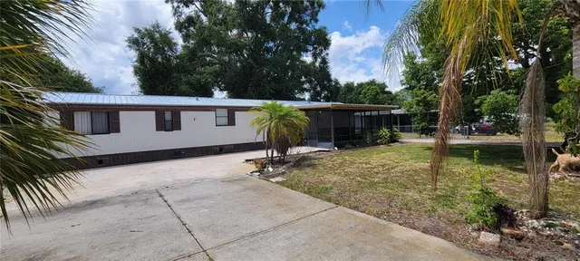a view of a house with backyard and sitting area