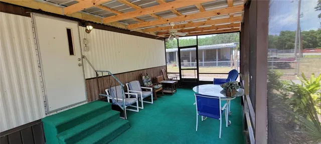 a porch with a bench next to a yard