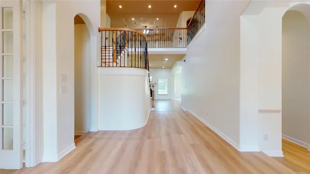 a view of a hallway with wooden floor and staircase