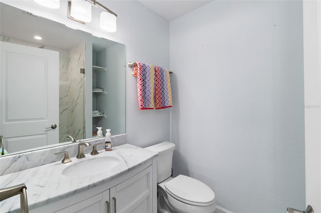 460-5 Gulf Boulevard, Unit 4 Boca Grande, FL 33921 - Photo 18 of 26 a bathroom with a granite countertop sink mirror vanity and toilet