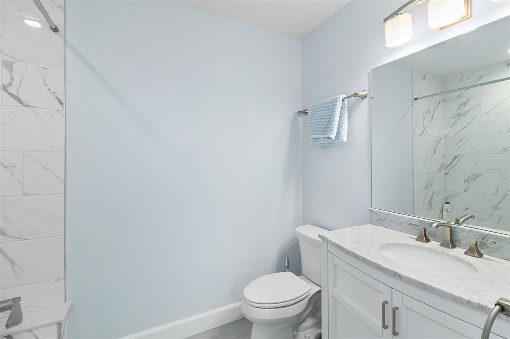 460-5 Gulf Boulevard, Unit 4 Boca Grande, FL 33921 - Photo 21 of 26 a white toilet sitting next to a bathroom sink