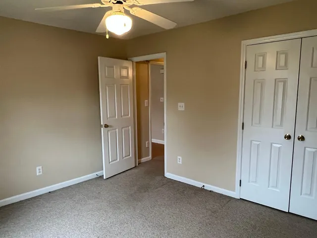 an empty room with chandelier fan