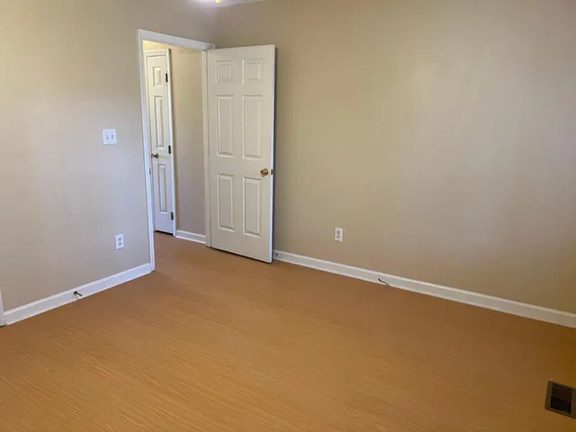 an empty room with a window and a ceiling fan