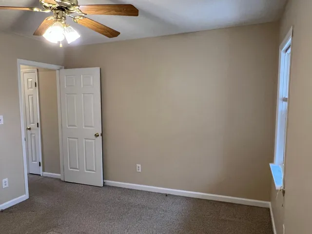 an empty room with a fan and a fan