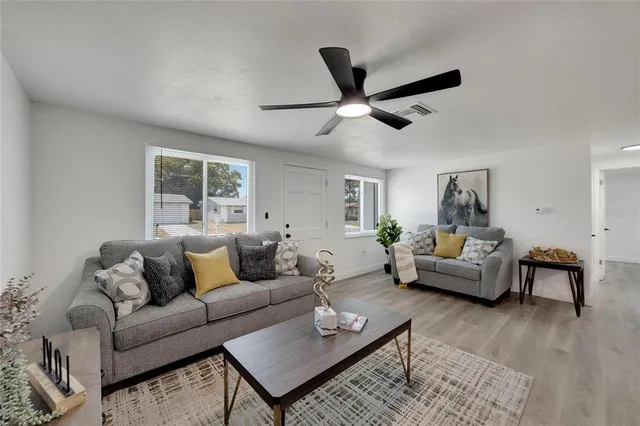 a kitchen with stainless steel appliances a dining table chairs and refrigerator