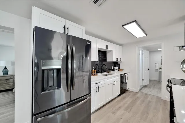 a living room with stainless steel appliances granite countertop a stove top oven a dining table and chairs with wooden floor