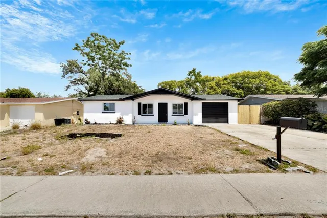 a white house with a large tree in front of it