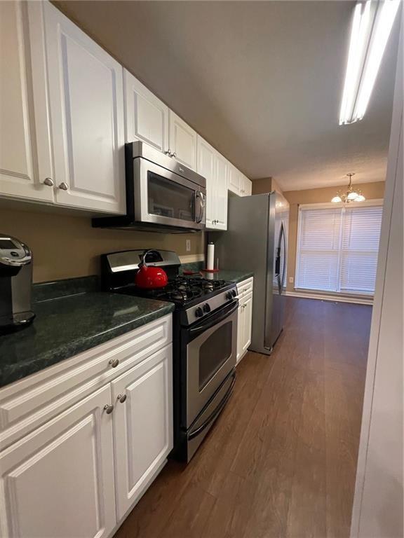 103 Live Oak Court Dallas, GA 30157 - Photo 3 of 25 a kitchen with stainless steel appliances granite countertop a sink a stove a microwave and cabinets