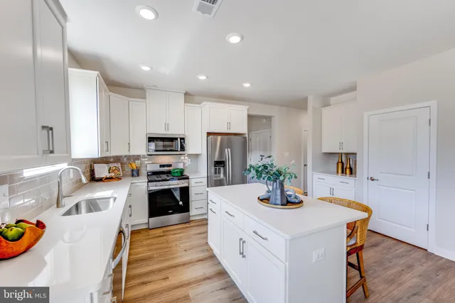 a kitchen with kitchen island granite countertop lots of counter top space and stainless steel appliances
